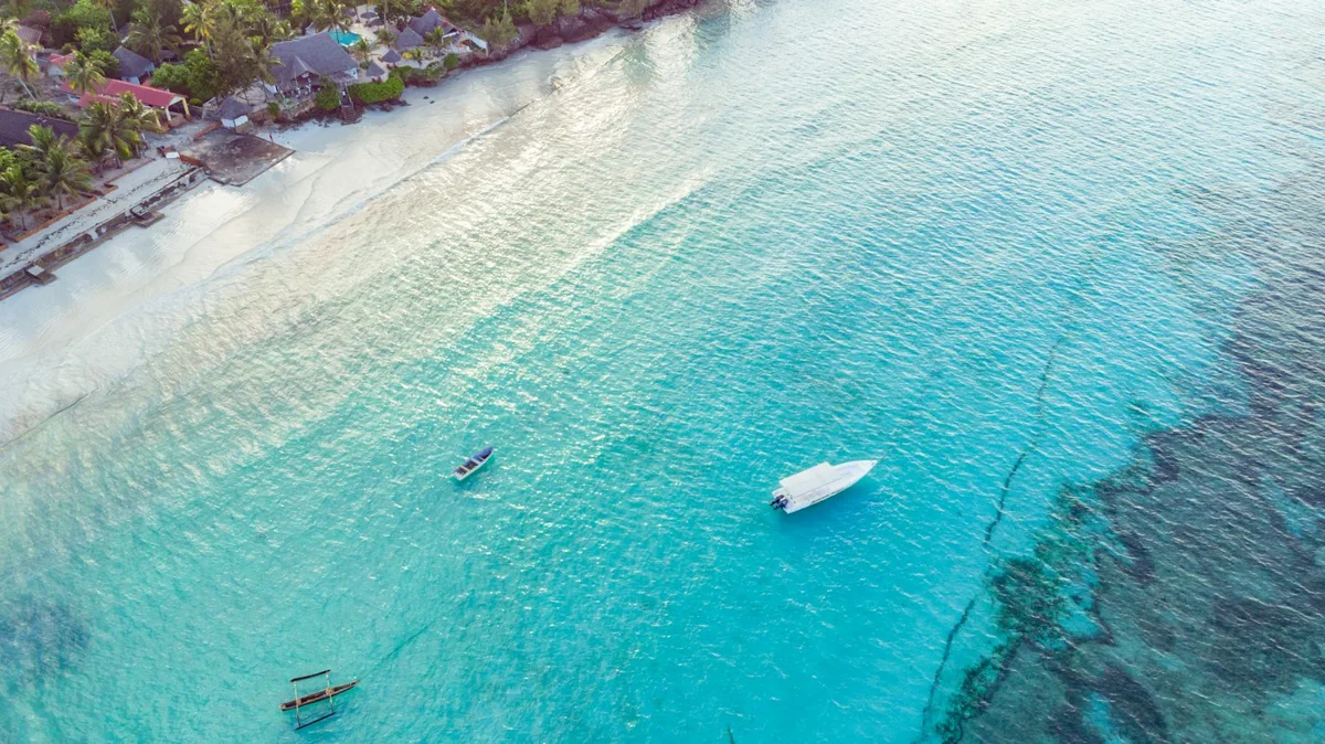 Aerial view of turquoise water and the Zanzibar shoreline